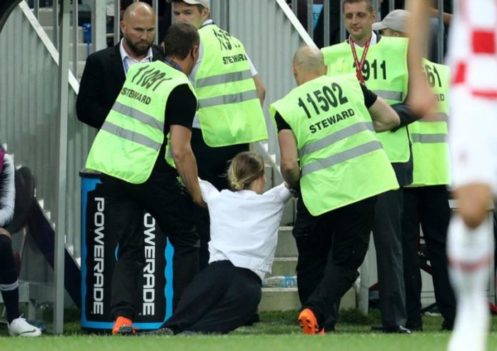 DIAMANKAN PETUGAS. Salah seorang anggota Pussy Riot diamankan petugas keamanan ketika masuk lapangan pertandingan babak Final Piala Duna di Stadion Luzhniki, Rusia, Minggu (15/7). Angger Bondan/Jawa Pos