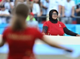 VOLUNTER DARI INDONESIA. Mita Yulian Sasmita, sukarelawan Piala Dunia 2018 asal Indonesia, saat bertugas memegang bendera Argentina sebelum pertandingan 16 besar Prancis-Argentina, di Kazan Arena, Rusia, Sabtu (30/6). Angger Bondan-Jawa Pos