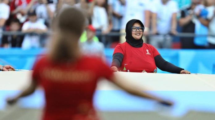 VOLUNTER DARI INDONESIA. Mita Yulian Sasmita, sukarelawan Piala Dunia 2018 asal Indonesia, saat bertugas memegang bendera Argentina sebelum pertandingan 16 besar Prancis-Argentina, di Kazan Arena, Rusia, Sabtu (30/6). Angger Bondan-Jawa Pos