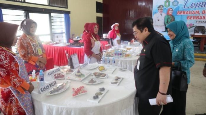 MENU LOMBA. Dodi Riyadmadji didamping Tita Kadarsari melihat menu peserta dalam LCM B2SA Berbasis Sumber Daya Lokal Tingkat Provinsi Kalbar di Balai Pertemuan Bhinneka Karya Abadi Gedung Korpri Pontianak, Kamis (19/7). Humas Pemprov for RK