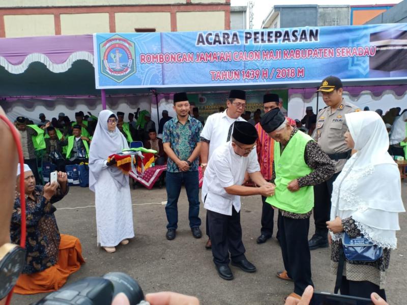 PASANG JAKET. Wakil Bupati Sekadau. Aloysius memasang jaket kepada salah seorang perwakilan CJH Sekadau di terminal bus Lawang Kuari, Sabtu pagi (28/7). Abdu Syukri-RK