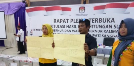 Arsip Tayan Hulu Hilang, YAS Minta Pemilu Ulang PROTES. Dua pendukung pasangan YAS membentengkan poster bertuliskan Pilkada ulang dan Pilkada cacat hukum di ruang rapat pleno, Jumat (6/7). Warga for RK