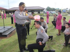 NAIK PANGKAT. Kapolres Kapuas Hulu AKBP Imam Riyadi melakukan prosesi penyiraman air kembang kepada personel yang mendapat kenaikan pangkat di Halaman Mapolres Kapuas Hulu, Sabtu (30/6)—Andreas/RK