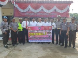 PERANGI PUNGLI. Kapolsek Pontianak Kota beserta jajarannya berfoto bersama dengan spanduk stop pungli, Rabu (25/7)--Polisi for RK