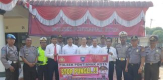 Polsek Pontianak Kota Ajak Masyarakat Perangi Pungli PERANGI PUNGLI. Kapolsek Pontianak Kota beserta jajarannya berfoto bersama dengan spanduk stop pungli, Rabu (25/7)--Polisi for RK
