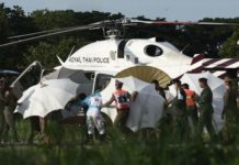 Tim yang Sama untuk Gua yang Sama HELIKOPTER EVAKUASI. Petugas penyelamat ke tandu dekat helikopter polisi di bandara militer di Chiang Rai. AFP