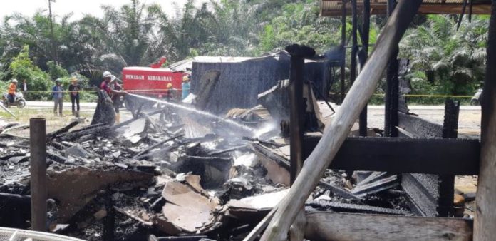 PEMADAMAN. Petugas dan warga berjibaku memadamkan api yang membakar rumah dan bengkel milik Alex di Belitang Hilir, Senin (2/7)--Polsek Belitang Hilir for Rakyat Kalbar