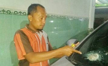 Semobil dengan Istri dan Anak, Batu Hantam Kaca Depan RUSAK: Mohammad Johan menunjukkan batu yang masih berada di kaca depan mobil miliknya Senin malam (2/7). (MOHAMMAD JOHAN FOT Radar Madura/JawaPos.com)