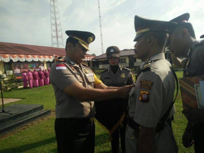 PASANG TANDA JABATAN. Kapolres Kapuas Hulu AKBP R Siswo Handoyo memasang tanda jabatan kepada Iptu Parwana dengan jabatan baru sebagai Kapolsek Seberuang, pada acara sertijab di Halaman Mapolres, Senin (6/8)—Andreas/RK