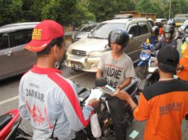 BAGI MASKER. Anggota damkar swasta membagikan masker kepada pengendara di traffic light Digulis Untan, Kamis sore (23/8). Maulidi Murni-RK