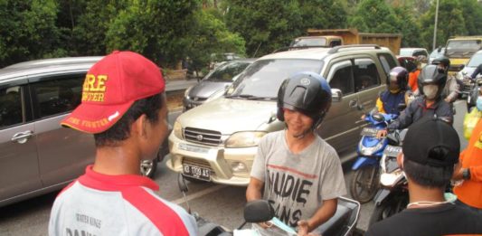 Damkar Swasta Bagi-bagi Masker BAGI MASKER. Anggota damkar swasta membagikan masker kepada pengendara di traffic light Digulis Untan, Kamis sore (23/8). Maulidi Murni-RK