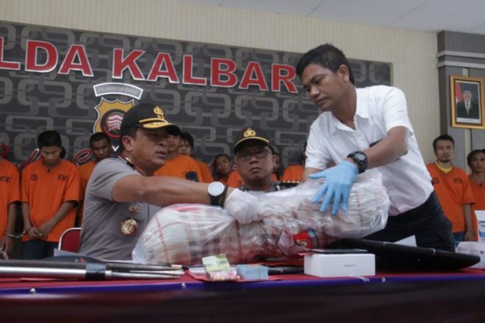 BARANG BUKTI. Kapolda Kalbar, Irjen Pol Didi Haryono dan Kasat Reskrim Polresta Pontianak menunjukkan salah satu barang bukti kejahatan dalam konferensi pers yang digelar di Balai Kemitraan Mapolda Kalbar, Kamis (9/8)—Bid Humas Polda Kalbar for RK