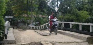 Kondisi Jembatan Sungai Boli Berlubang dan Mengancam Keselamatan Warga Jembatan Berlubang. Warga berkendara melalui jembatan Sungai Boli yang kondisi lantainya sudah berlubang serta mengancam keselamatan warga yang melintas. Warga for Rakyat Kalbar