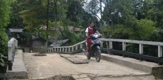 Kondisi Jembatan Sungai Boli Berlubang dan Mengancam Keselamatan Warga Jembatan Berlubang. Warga berkendara melalui jembatan Sungai Boli yang kondisi lantainya sudah berlubang serta mengancam keselamatan warga yang melintas. Warga for Rakyat Kalbar
