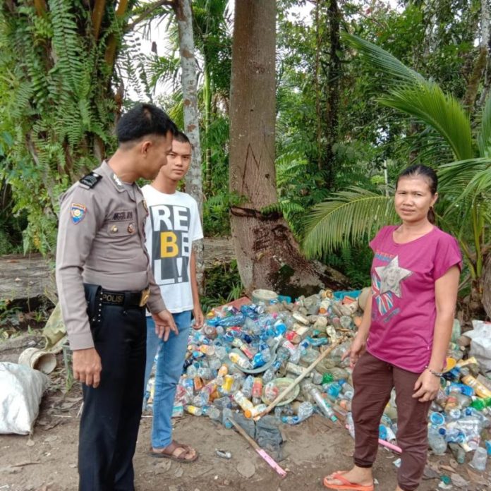 LOLOS SELEKSI. Bhabinkamtibmas Desa Sungai Ringin, Brigadir Anggre Jaya Laksana bertemu dengan Niko dan ibunya di Desa Sungai Ringin, Jumat (3/8). Meski ayah dan ibunya merupakan pemulung dan buruh cuci, Niko berhasil lolos Seleksi Penerimaan Bintara Polri Tahun 2018. Abdu Syukri