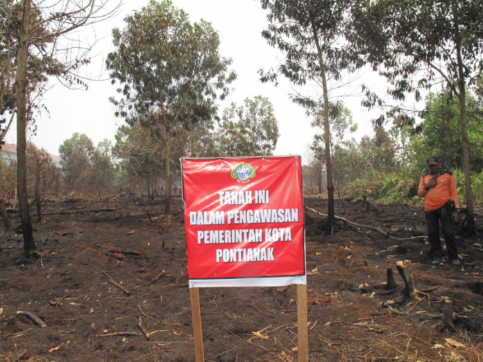 PLANG. Penancapan plang disalah satu lahan terbakar di Jalan Parit H Husin 2, Bansir Darat, Pontianak Tenggara, Sabtu (25/8). Maulidi Murni-RK