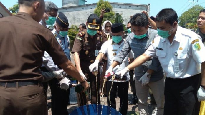 PEMUSNAHAN. H. Atbah Romin Suhaili bersama Muhammad Kandi dan lainnya musnahkan barang bukti kejahatan yang telah mempunyai kekuatan hukum tetap di halaman Kejari Sambas, Rabu (15/8). Sairi-RK