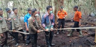 Untan Terancam Sanksi PADAMKAN API. Edi Rusdi Kamtono (berbaju batik) membantu petugas Damkar memadamkan api kebakaran lahan milik Untan Pontianak, Kamis (23/8). Bangun Subekti-RK