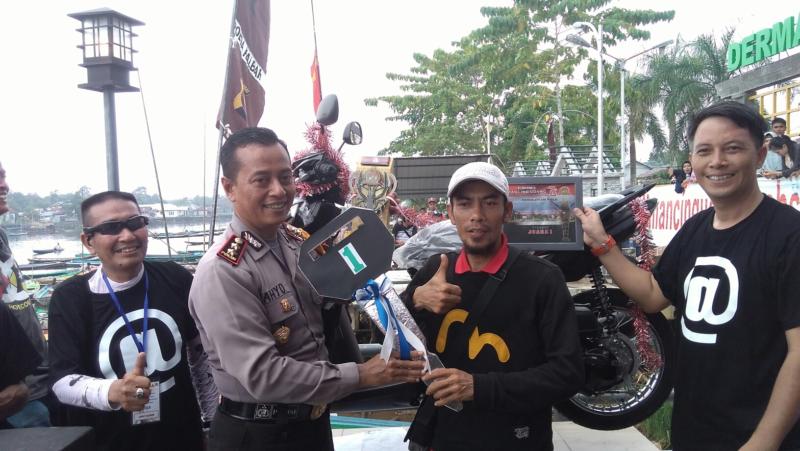 MENANG MANCING. Kapolres Sambas, AKBP Cahyo Hadiprabowo bersama Wakapolres Sambas, Kompol Jovan R Sumual menyerahkan sepeda motor matic kepada Muhlis di Dermaga Wisata Desa Dalam Kaum, Kecamatan Sambas, Minggu (26/8). Warga Desa Sekura, Kecamatan Teluk Keramat itu memenangkan Turnamen Mancing Udang Piala Polres Sambas dan Komunitas Memancing Kabupaten Sambas. Sairi/Rakyat Kalbar