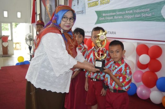 Pemberian Hadiah. Anak-anak yang beruntung mendapat hadiah dari Asisten Administrasi dan Umum Setda KKU, Munirah di puncak peringatan Hari Anak di Balai Praja Sukadana, Rabu (29/8). Kamiriluddin/RK.