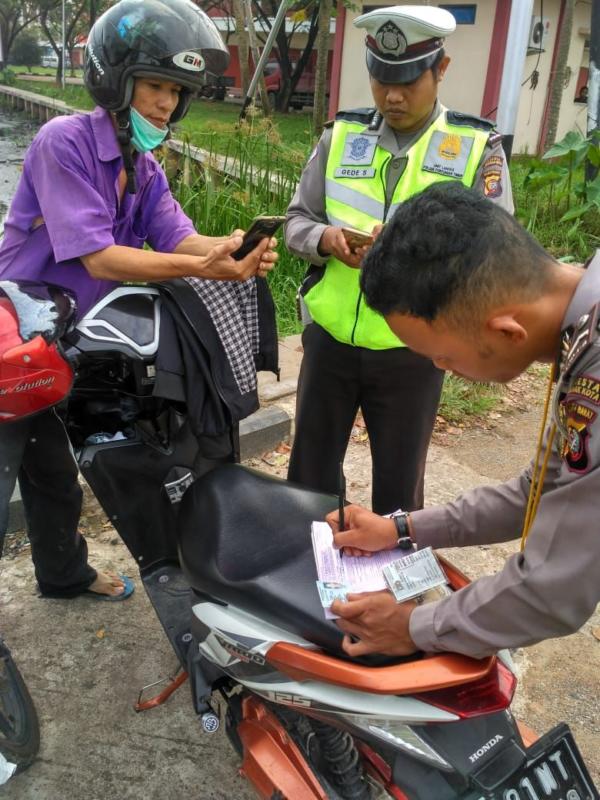 TILANG. Petugas Sat Lantas sedang mengecek kelengkapan surat menyurat pengendara, belum lama ini--Polisi for RK